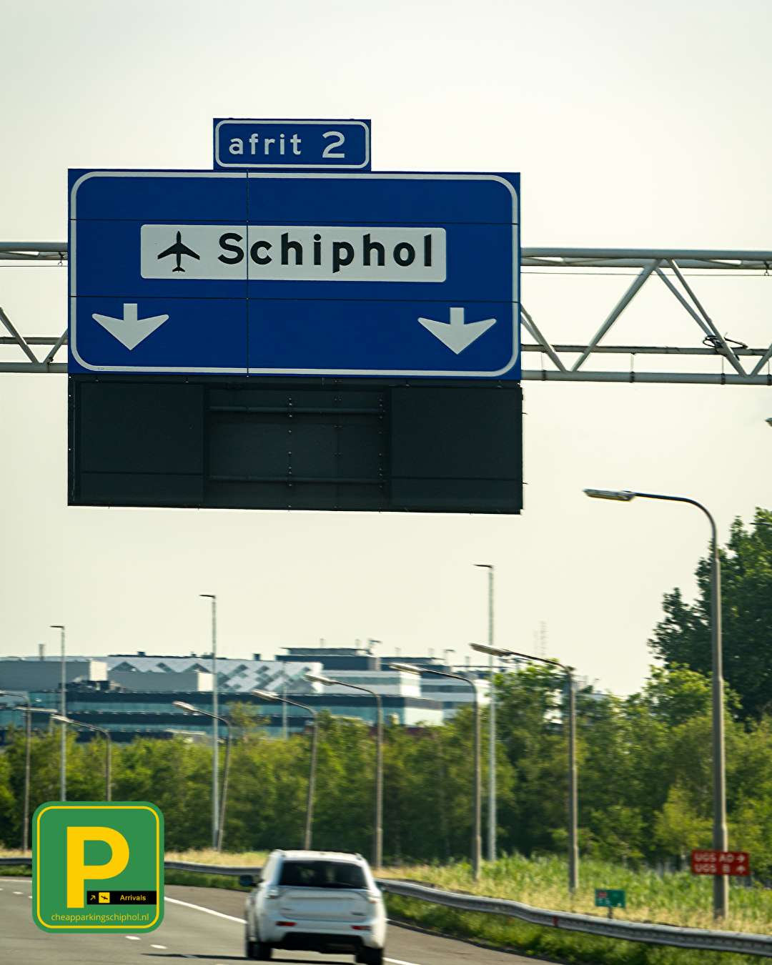 Verkeersbord met afrit 2 naar Schiphol op de snelweg, perfect moment voor reizigers om lang parkeren Schiphol te regelen via cheapparkingschiphol.nl.